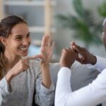 smiling mixed ethnicity couple talking with sign finger hand language